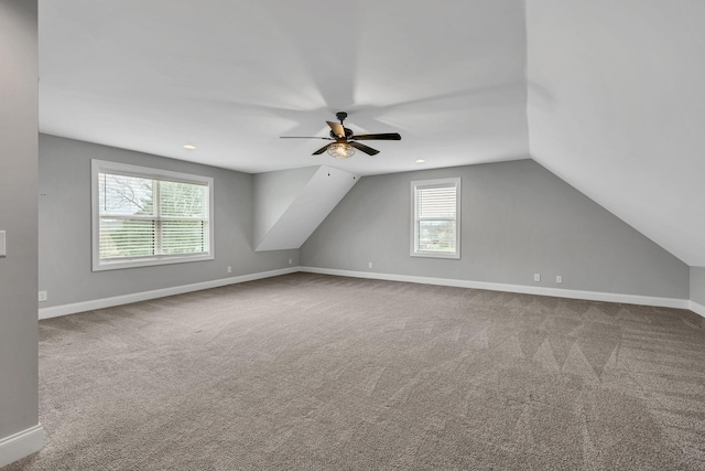 additional living space featuring lofted ceiling, carpet, baseboards, and a ceiling fan