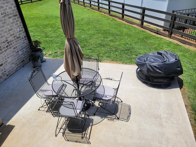 view of patio featuring a grill, fence, and outdoor dining space