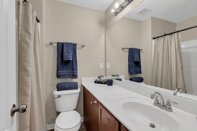 bathroom with vanity, a textured ceiling, and toilet