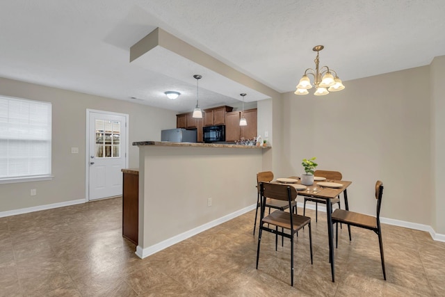 dining space with an inviting chandelier and a textured ceiling