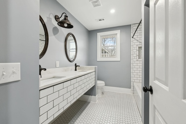 full bathroom featuring vanity, tiled shower / bath, tile patterned floors, and toilet