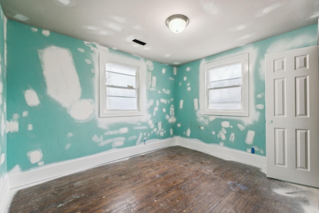 spare room with hardwood / wood-style flooring and a wealth of natural light