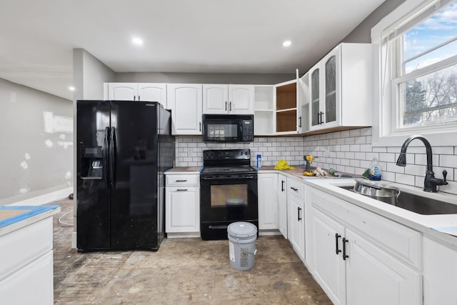 kitchen featuring white cabinets, sink, decorative backsplash, and black appliances