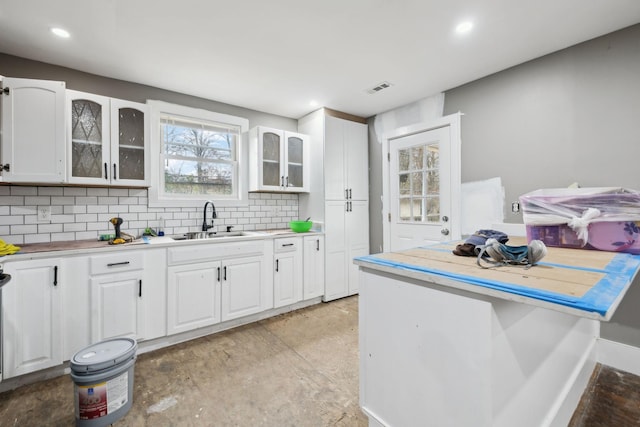 kitchen featuring sink, decorative backsplash, and white cabinets