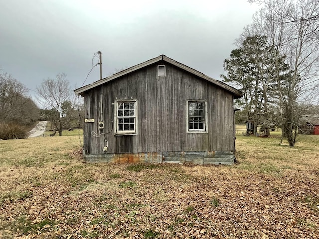 view of home's exterior with an outbuilding and a yard