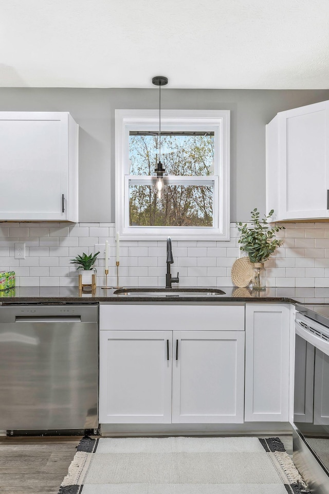 kitchen featuring sink, tasteful backsplash, decorative light fixtures, stainless steel appliances, and white cabinets