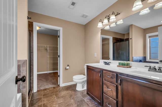 bathroom featuring vanity, toilet, and walk in shower