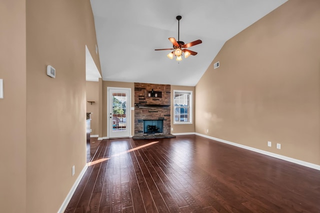 unfurnished living room with ceiling fan, dark hardwood / wood-style floors, high vaulted ceiling, and a stone fireplace