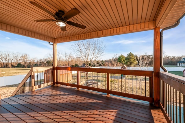 deck featuring ceiling fan and a water view