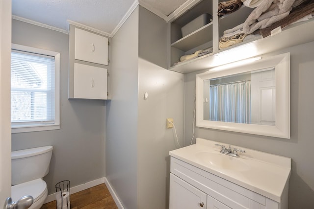 bathroom with vanity, hardwood / wood-style floors, ornamental molding, and toilet