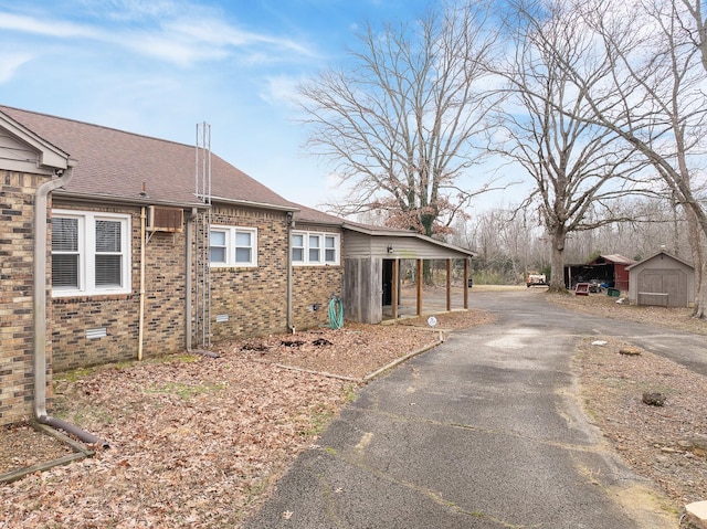 view of property exterior featuring a carport and a shed