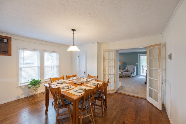 dining room with crown molding, a wall unit AC, a textured ceiling, dark hardwood / wood-style flooring, and french doors