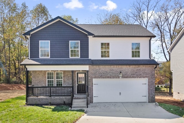 view of front of home with a garage, a front yard, and covered porch