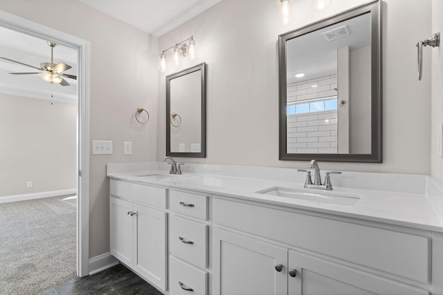 bathroom featuring double vanity, a sink, visible vents, and baseboards