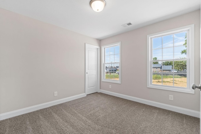 unfurnished room featuring visible vents, baseboards, and carpet flooring