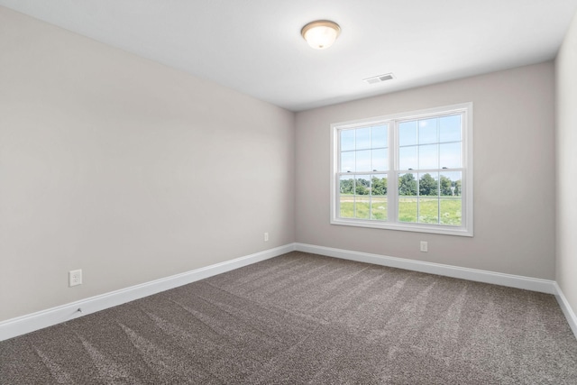 spare room featuring carpet, visible vents, and baseboards