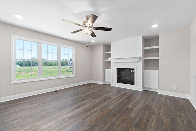 unfurnished living room with dark hardwood / wood-style flooring, ceiling fan, and a fireplace