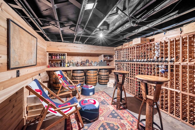 wine cellar featuring bar and wood walls