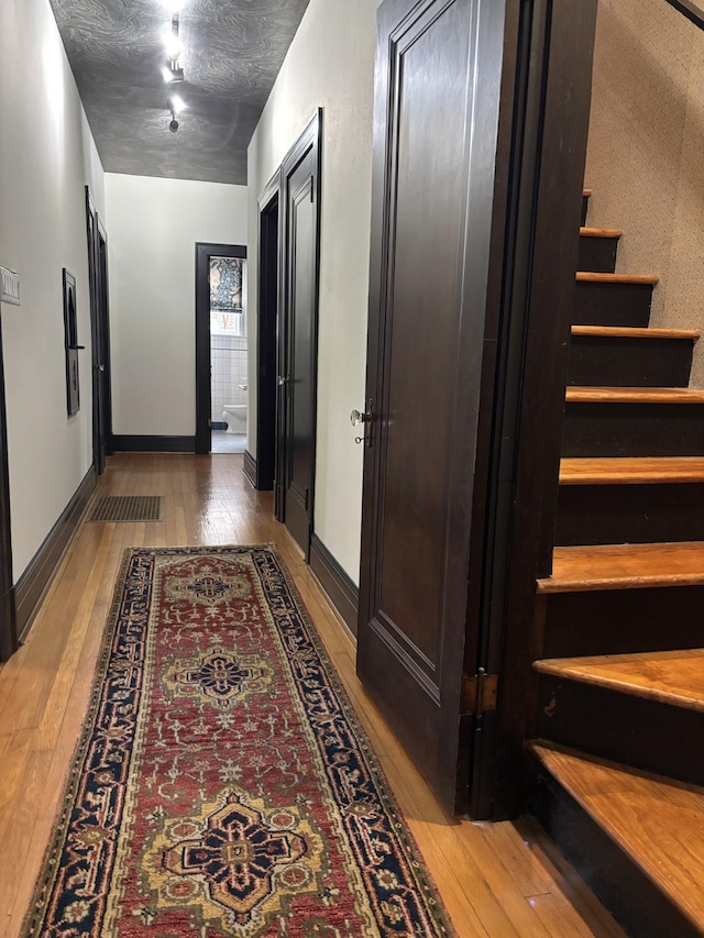 corridor with hardwood / wood-style flooring