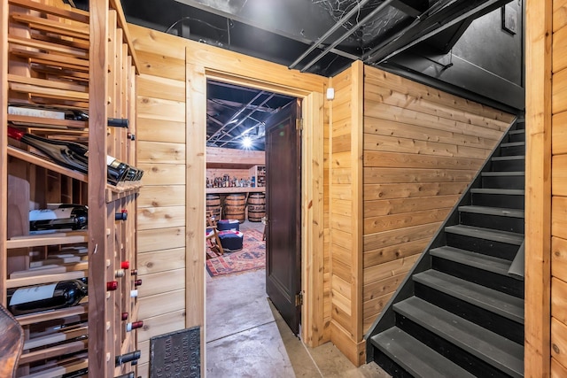 wine room featuring concrete floors and wood walls