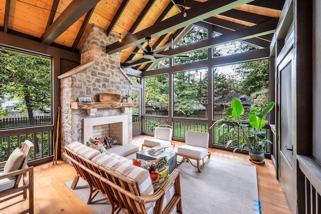 sunroom / solarium featuring vaulted ceiling with beams, a wealth of natural light, wood ceiling, and a fireplace