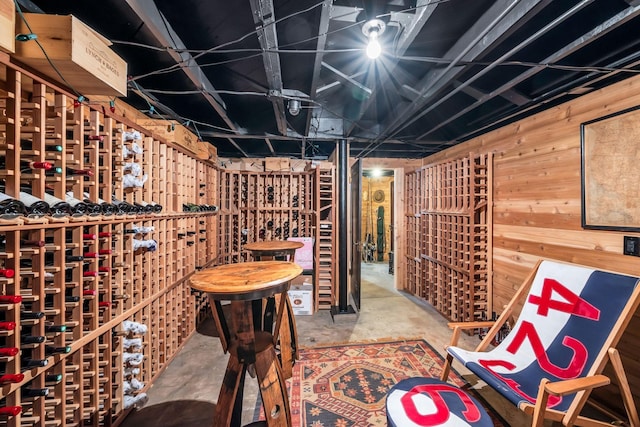 wine area featuring wooden walls and concrete floors