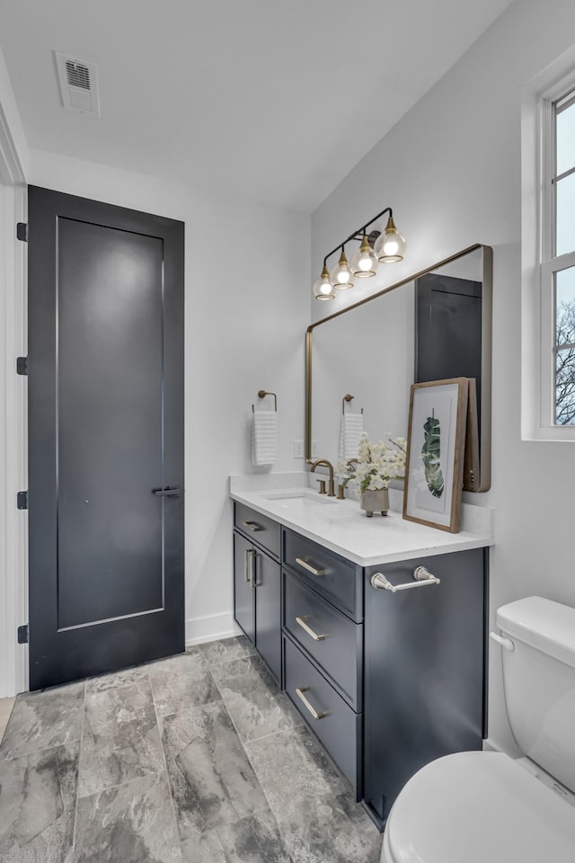 bathroom featuring vanity and toilet