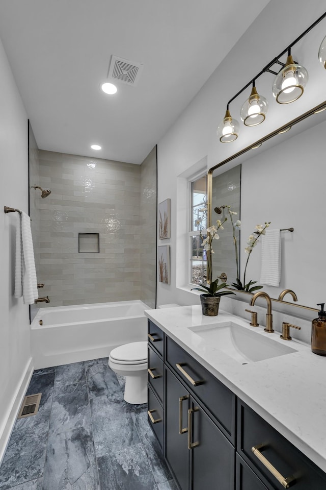 full bathroom with tiled shower / bath, vanity, and toilet