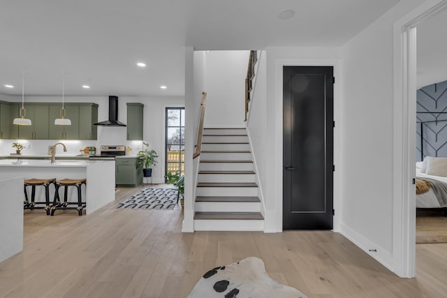 stairs featuring wood-type flooring and sink