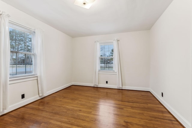 spare room featuring hardwood / wood-style flooring and plenty of natural light