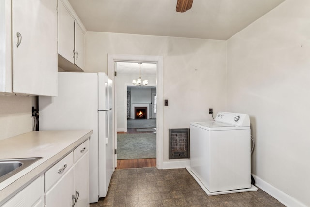 washroom featuring heating unit, sink, washer / dryer, and ceiling fan