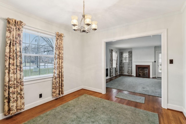 unfurnished dining area featuring dark hardwood / wood-style flooring, a fireplace, and ornamental molding