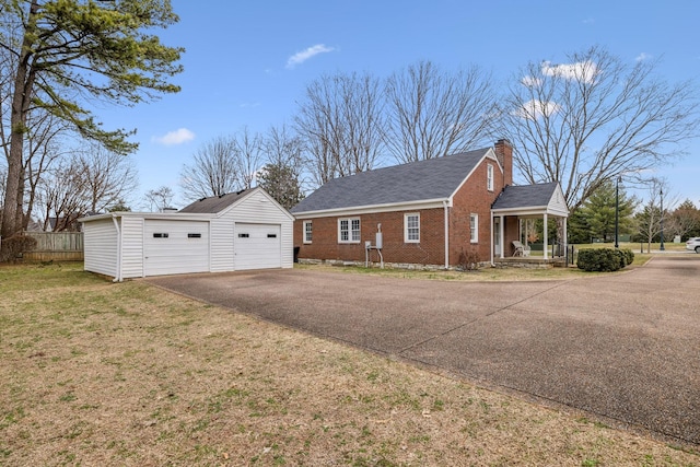 view of side of home featuring a garage, an outdoor structure, a lawn, and a porch