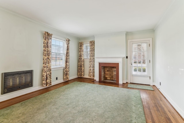 unfurnished living room with hardwood / wood-style floors, a healthy amount of sunlight, heating unit, and a fireplace