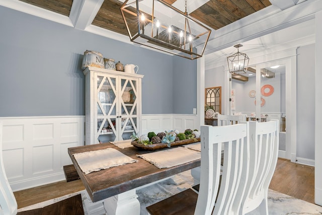 dining room with beamed ceiling, dark hardwood / wood-style flooring, ornamental molding, coffered ceiling, and a notable chandelier