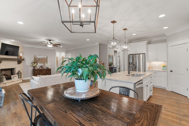 dining space with sink, crown molding, and a fireplace