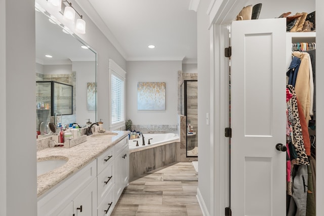 bathroom featuring vanity, separate shower and tub, hardwood / wood-style floors, and crown molding