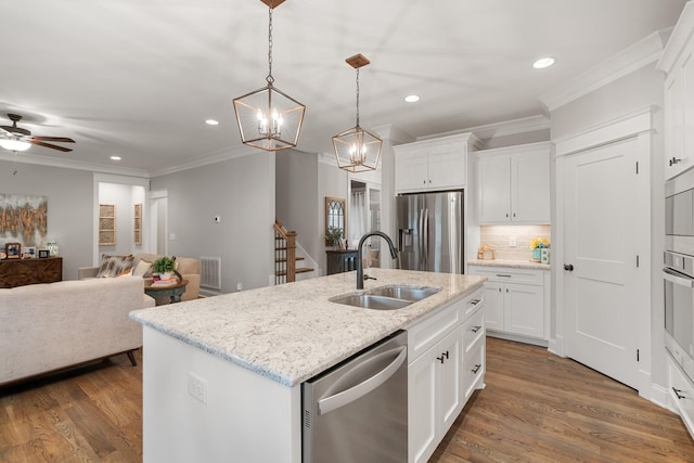 kitchen with white cabinetry, appliances with stainless steel finishes, sink, and a center island with sink