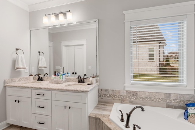 bathroom featuring crown molding, vanity, and a tub