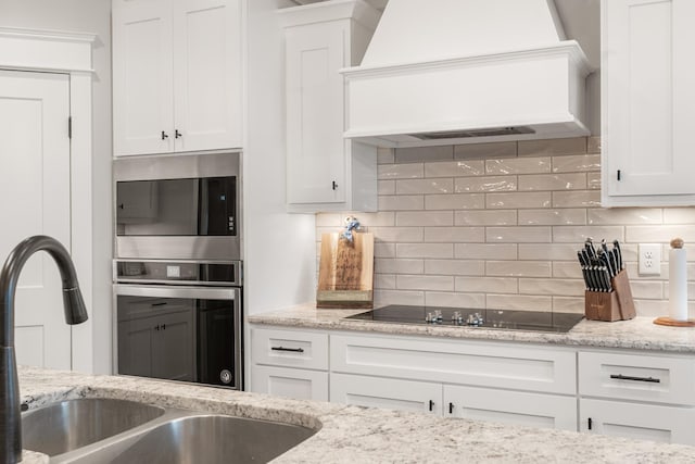 kitchen with white cabinetry, sink, custom exhaust hood, and stainless steel appliances