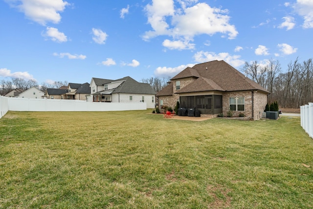 rear view of property with a sunroom and a lawn