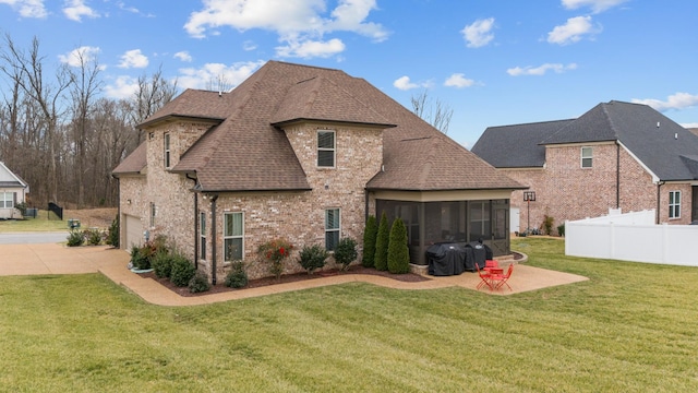 back of house featuring a yard, a patio area, a sunroom, and a garage