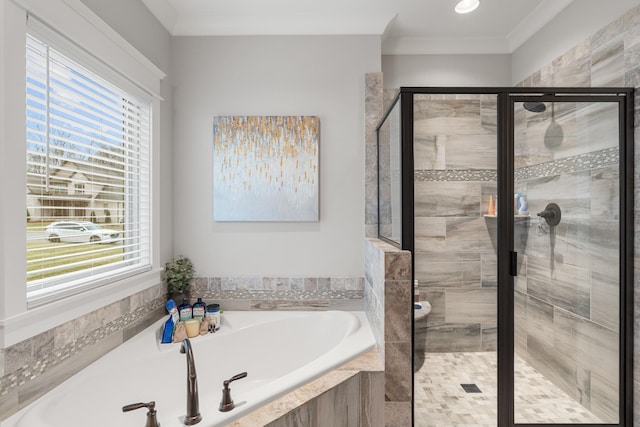 bathroom with ornamental molding and shower with separate bathtub