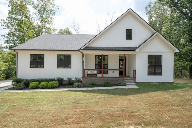 modern inspired farmhouse with a front yard and covered porch