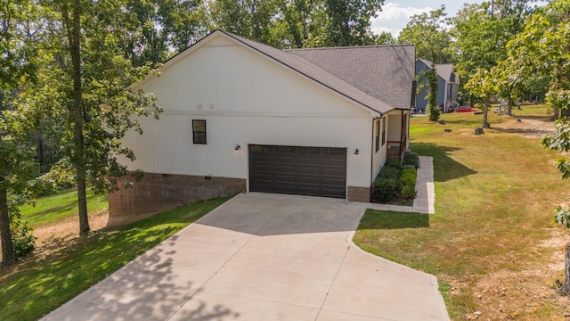 view of side of property featuring a garage and a lawn