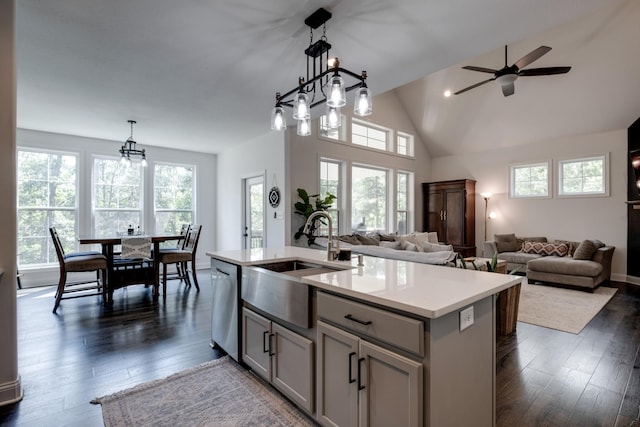 kitchen with gray cabinets, decorative light fixtures, dishwasher, sink, and a kitchen island with sink