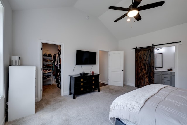 carpeted bedroom featuring high vaulted ceiling, a walk in closet, ceiling fan, a barn door, and a closet