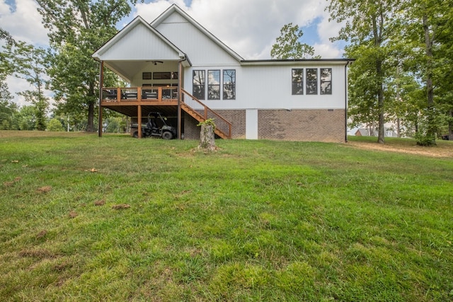 rear view of property with a wooden deck, ceiling fan, and a lawn