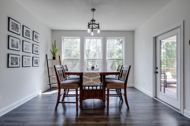 dining space with dark hardwood / wood-style floors and a chandelier