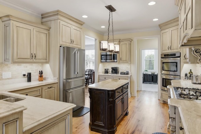 kitchen featuring pendant lighting, a center island, light hardwood / wood-style floors, stainless steel appliances, and crown molding